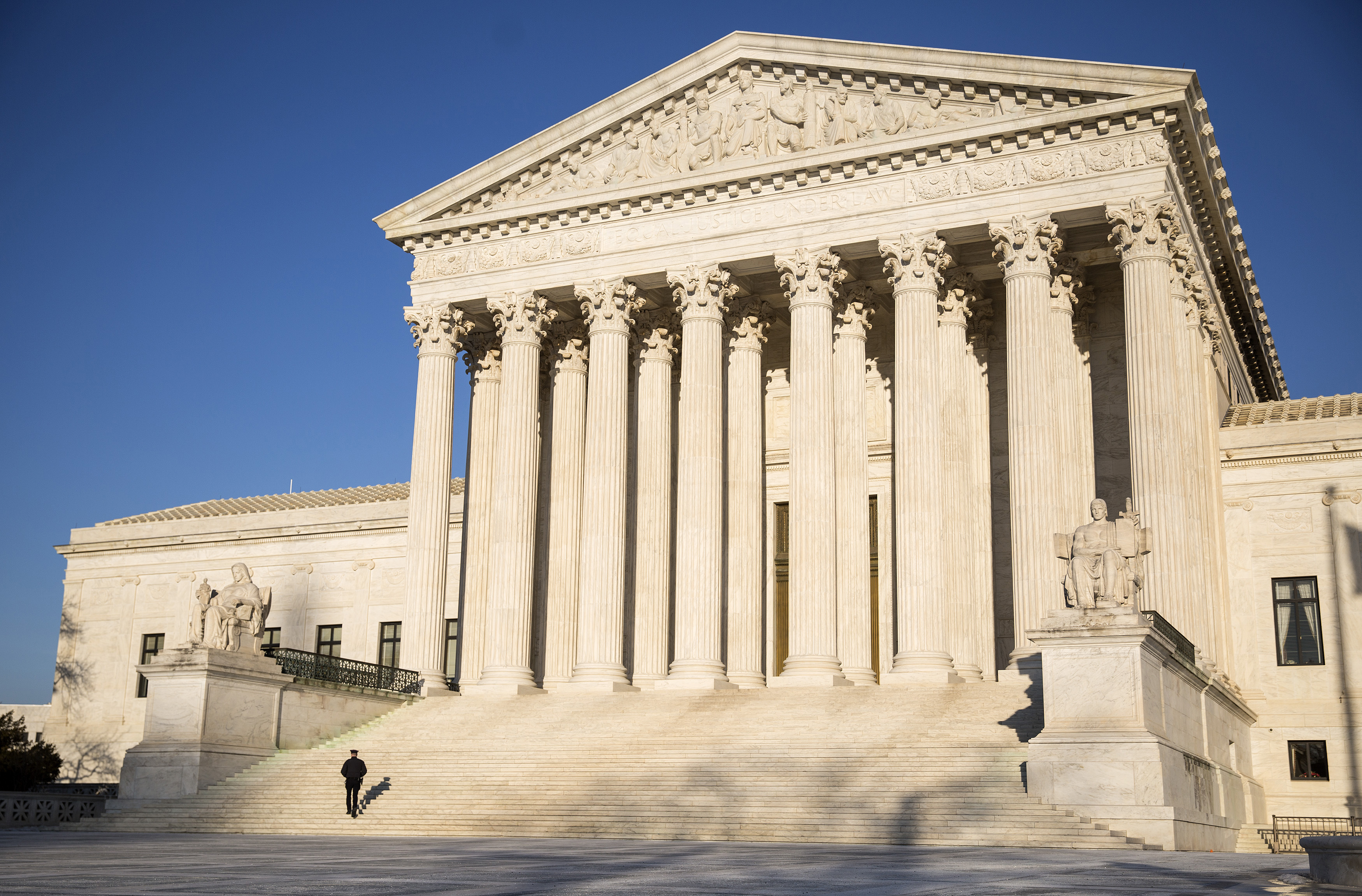 A police officer walks up the steps of the Supreme Court in Washington