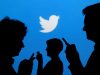 FILE PHOTO: People holding mobile phones are silhouetted against a backdrop projected with the Twitter logo in this illustration picture taken September 27, 2013. REUTERS/Kacper Pempel/Illustration/File Photo