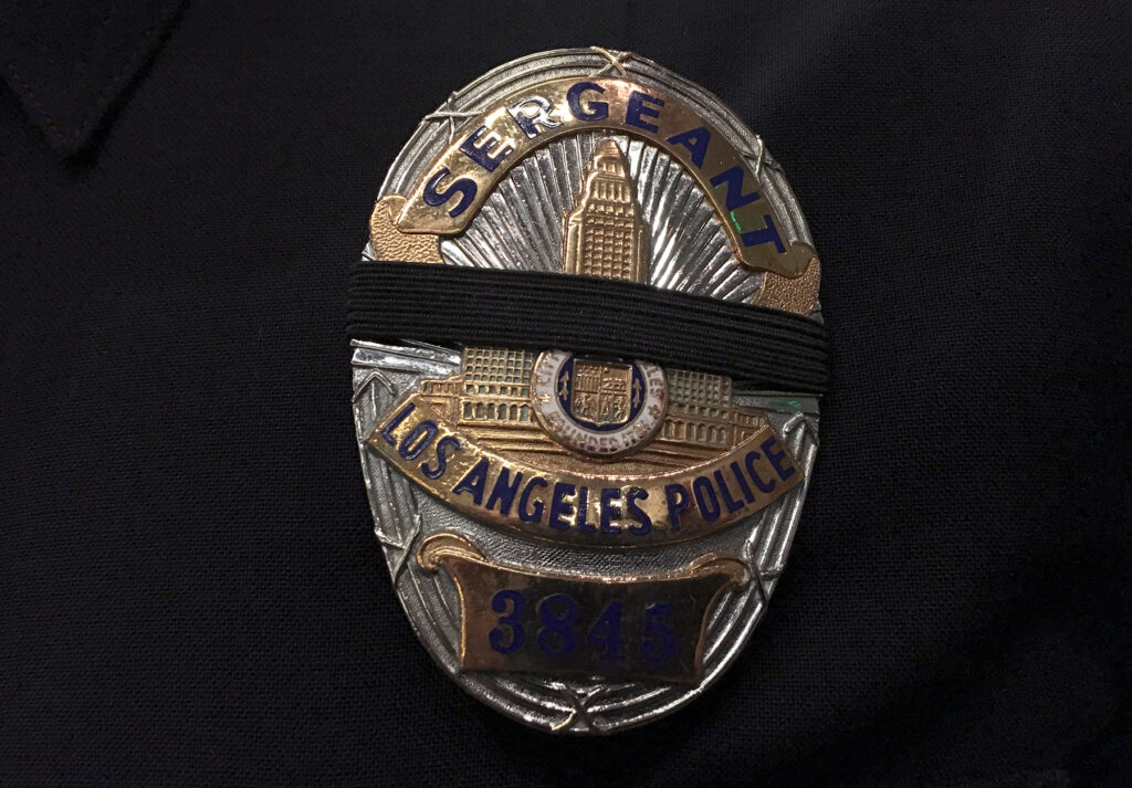 The badge of a Los Angeles Police Department sergeant is seen with a black band across it to mourn the deaths of the Dallas police officers, at a news conference in Los Angeles