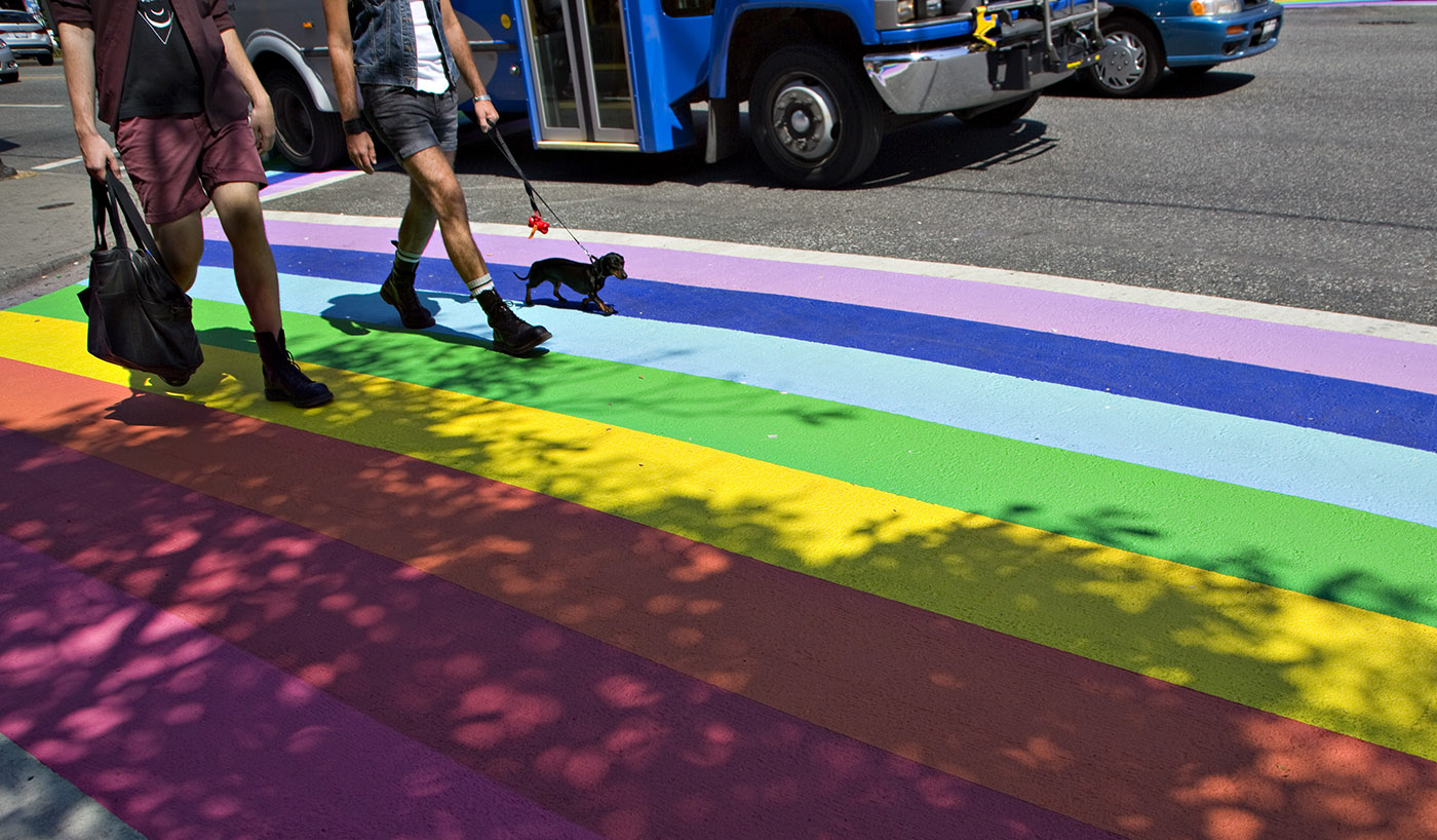 Local residents cross a rainbow painted crosswalk in Vancouver