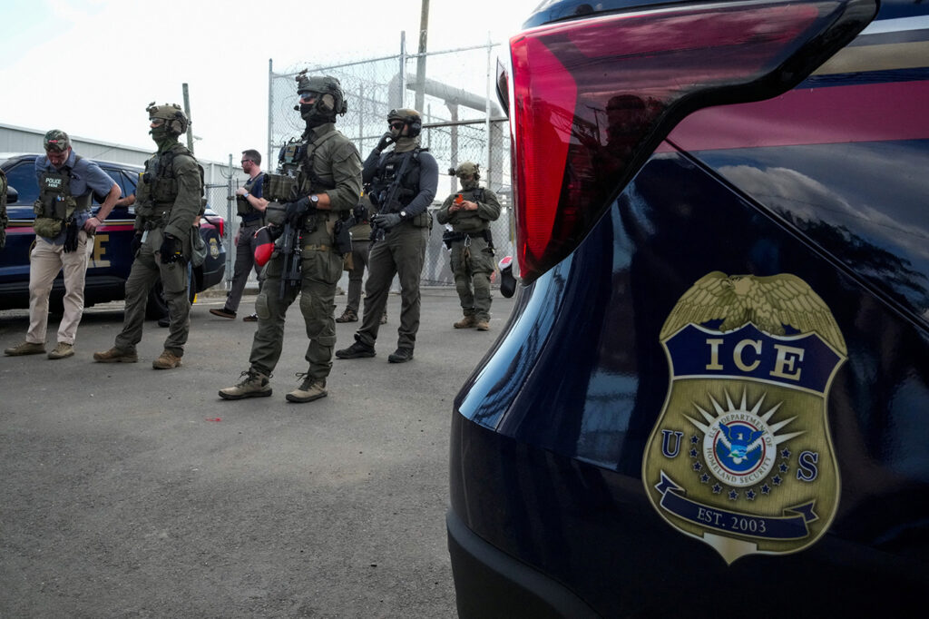 ICE agents secure the entrance to Delaney Hall detention center as demonstrators remain gathered in Newark