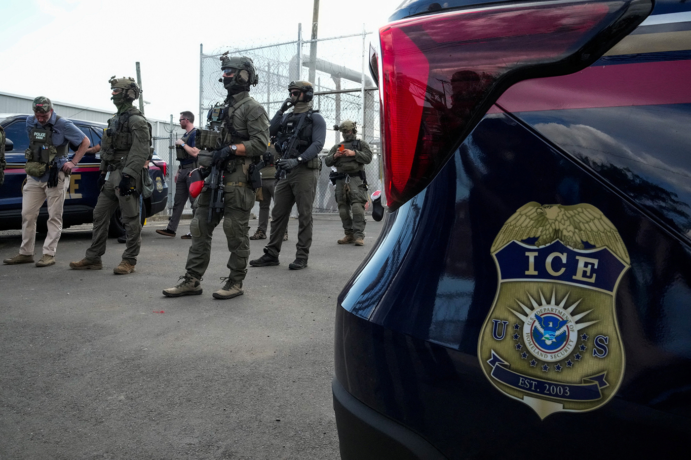ICE agents secure the entrance to Delaney Hall detention center as demonstrators remain gathered in Newark
